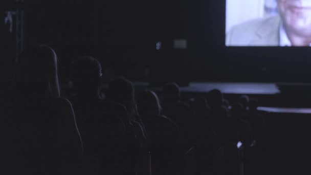 Les visiteurs d'un forum d'affaires regardent une présentation à l'écran — Video