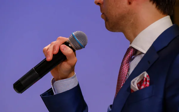 Muž mluví, drží mikrofon — Stock fotografie