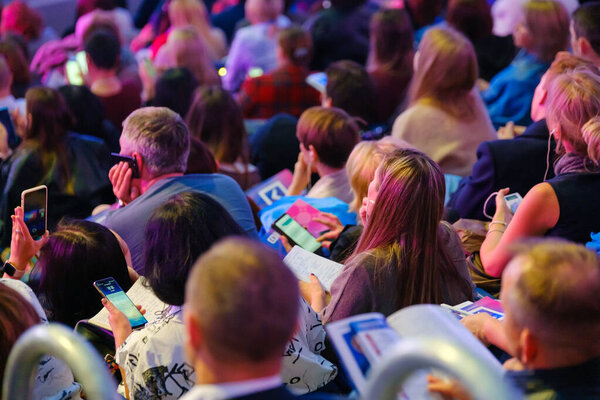 Business conference attendees sit and listen