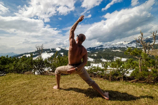 Hombre anónimo haciendo yoga en las montañas — Foto de Stock