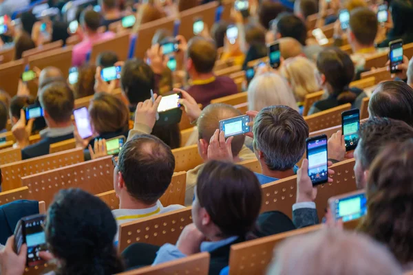 Conferentie deelnemers nemen foto 's op hun smartphone camera' s — Stockfoto