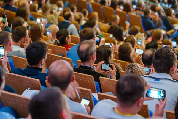 Konferansa katılanlar akıllı telefon kameralarıyla fotoğraf çekiyorlar