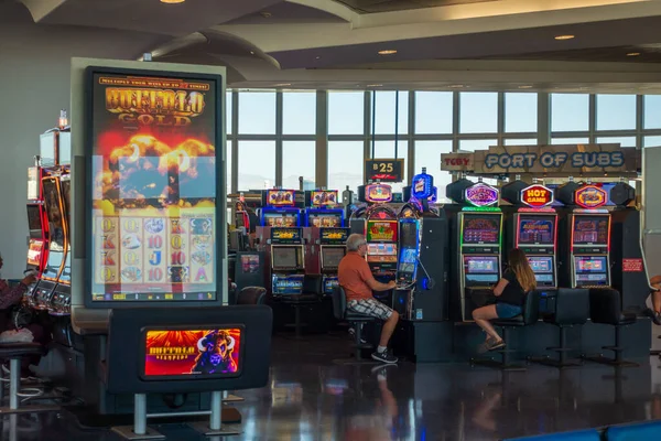 Люди играют на игровых автоматах в аэропорту — стоковое фото