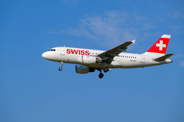 Самолеты швейцарских авиалиний готовятся к посадке в дневное время в международном аэропорту
