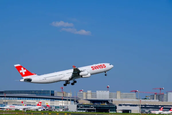 Швейцарські авіалайнери готуються до зльоту в денний час в міжнародному аеропорту — стокове фото