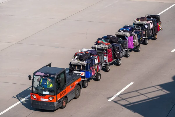 Погрузчик перевозит багаж пассажиров в аэропорту — стоковое фото