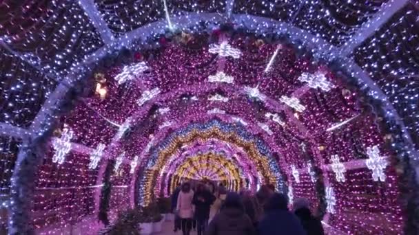 La gente cammina per le strade decorate con illuminazione per Natale la sera — Video Stock