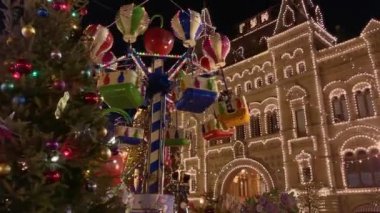 İnsanlar Noel pazarında atlıkarıncaya biniyor.