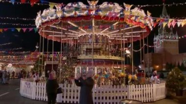 İnsanlar Noel pazarında atlıkarıncaya biniyor.