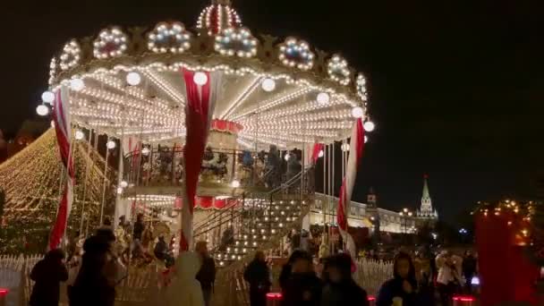 Lidé jezdí na kolotoči na vánočním trhu — Stock video