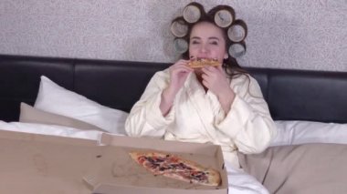 Plus size girl eats a slice of pizza