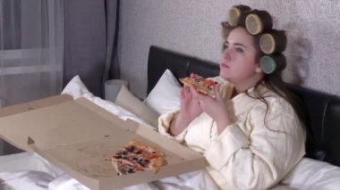 Plus size girl eats a slice of pizza