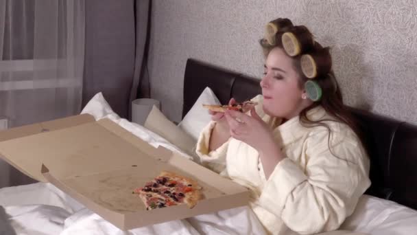 Plus size girl eats a slice of pizza — 图库视频影像