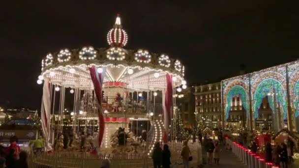 Folk åker karusell på julmarknaden. — Stockvideo