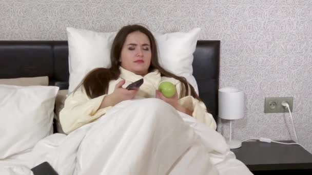 Plus size young woman lying in bed, talking by phone — Stock Video