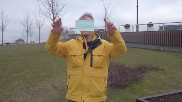 Человек демонстрирует, как носить медицинскую маску — стоковое видео