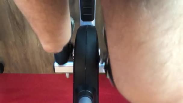 POV hombre en el gimnasio pedales de una bicicleta estática — Vídeo de stock