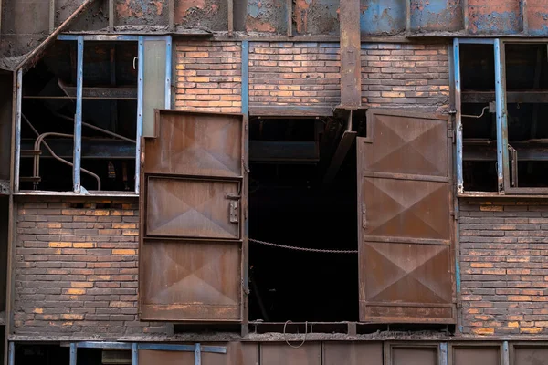 Janelas partidas numa parede de tijolos de uma fábrica abandonada — Fotografia de Stock