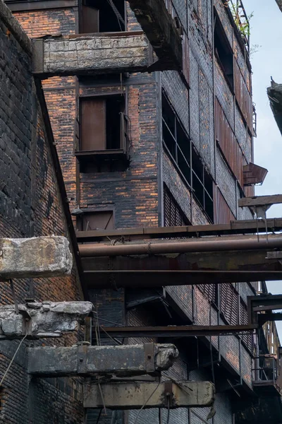 Janelas partidas numa parede de tijolos de uma fábrica abandonada — Fotografia de Stock