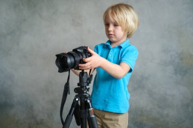 Çocuk profesyonel fotoğraf makinesiyle oynuyor.