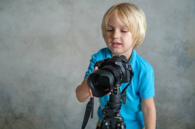 Çocuk profesyonel fotoğraf makinesiyle oynuyor.