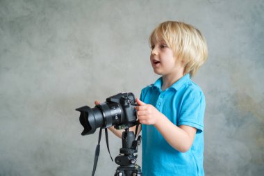 Çocuk profesyonel fotoğraf makinesiyle oynuyor.