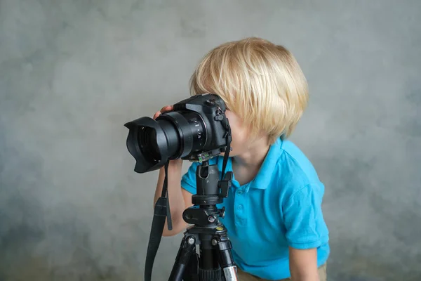 Menino brinca com uma câmera fotográfica profissional — Fotografia de Stock