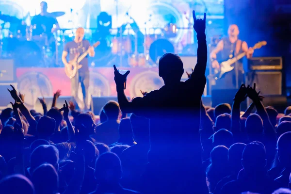 Fans at live rock music concert cheering