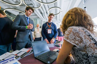 Konferans ziyaretçileri salonda sohbet ediyor.