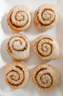 Tarçın ruloları beyaz tabakta.