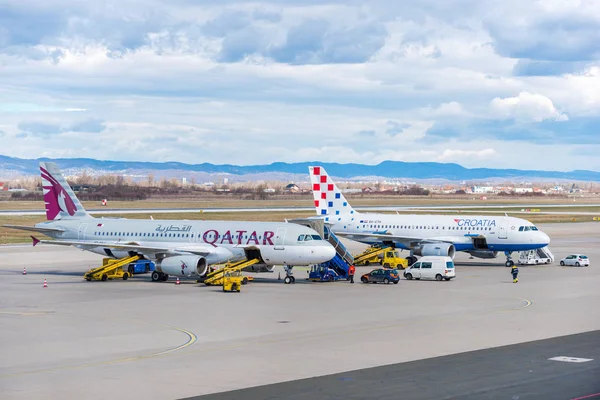 Qatar Airways e Croatia Airlines Airbuses no avental durante a transferência de bagagem . — Fotografia de Stock
