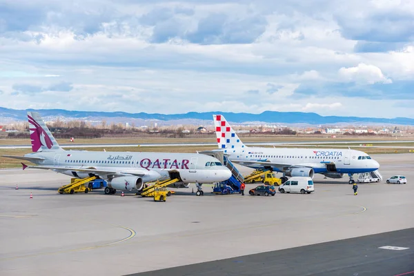 Qatar Airways a Chorvatsko letecké společnosti Airbus na odbavovací ploše během přenosu zavazadla. — Stock fotografie