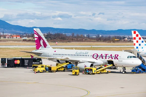 Qatar Airways e Croatia Airlines Airbuses em runway.during transferência de bagagem . — Fotografia de Stock