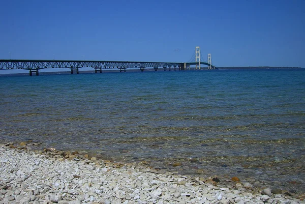 マキナック橋と岩のビーチ マキナック橋 吊り橋のミシガンの上下半島を接続します — ストック写真