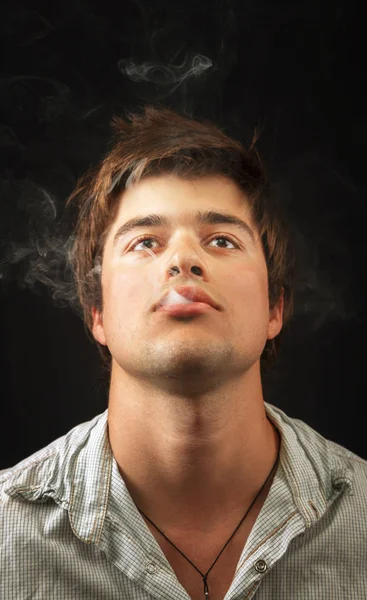 Genç rahat adam sigara ot — Stok fotoğraf