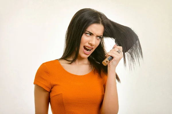 Problema de penteado confuso. Mulher escovando seu cabelo danificado — Fotografia de Stock