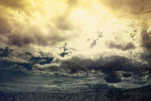 Global warming concept landscape. Dramatic cloudy sky and dry cracked earth
