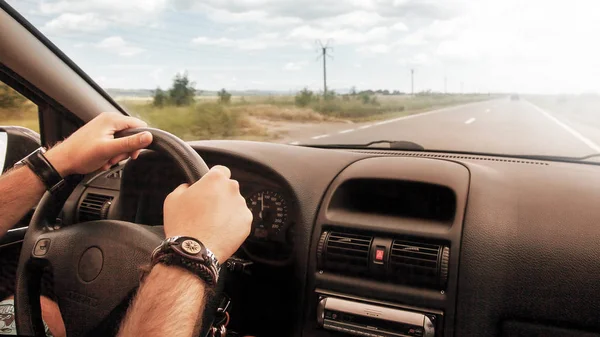 Manos conduciendo rueda de coche — Foto de Stock