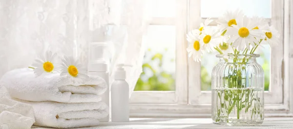 Towel with daisy flowers near window — Stock Photo, Image