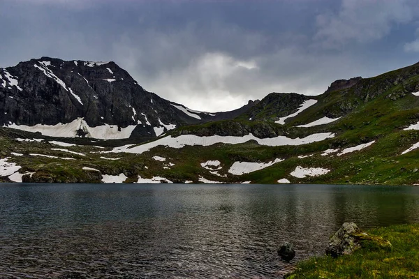 Большое холодное озеро высоко в горах Кавказа — стоковое фото