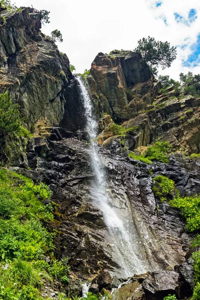 Водопад, текущий с крутой скалы в горах — стоковое фото