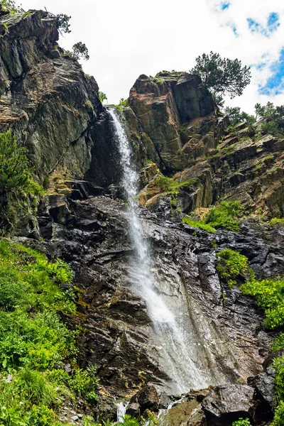 Chute d'eau coulant d'une falaise escarpée dans les montagnes — Photo