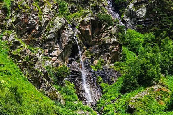 Waterfall flowing down a steep cliff in the mountains — Stock fotografie