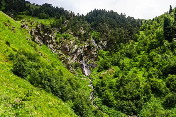 Waterfall flowing down a steep cliff in the mountains — Zdjęcie stockowe