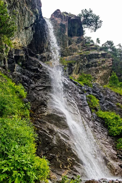 Waterfall flowing down a steep cliff in the mountains — Stock fotografie