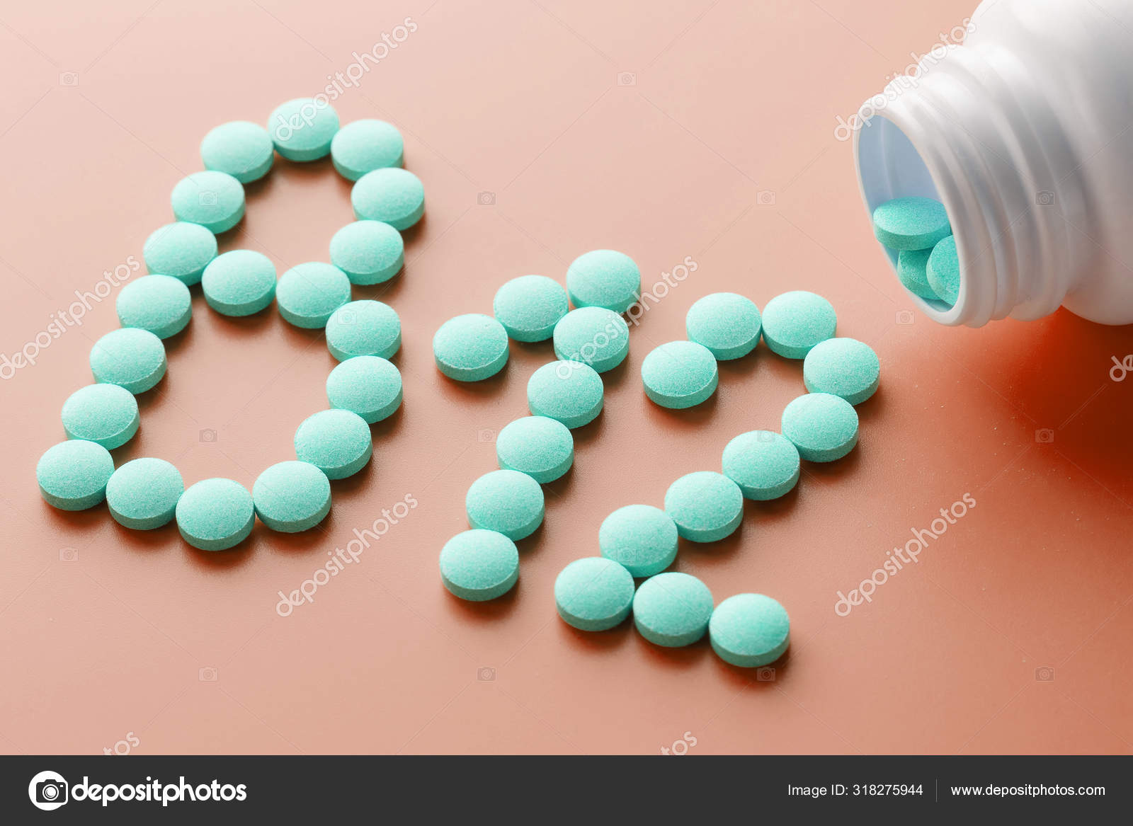 Vitamins B 12 on a red substrate, poured out of a white jar. — Stock