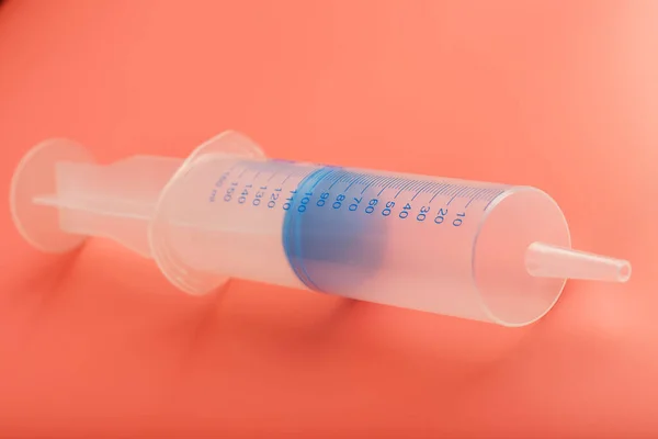 Large medical syringe on pink background with scale, copy space.