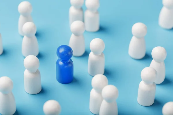 The leader of the blue color stands among the crowd, a group of white employees. The concept of leadership. Many employees are drawn to their boss. Personnel selection.