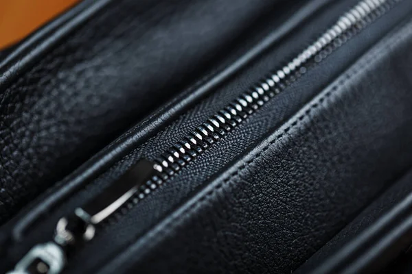Details and elements of the bag are handmade from black leather, close-up, macro locks.
