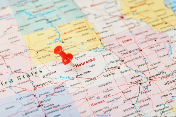 Red clerical needle on a map of USA, Nebraska and the capital Lincoln. Close up map of Nebraska with red tack, United States map pin USA
